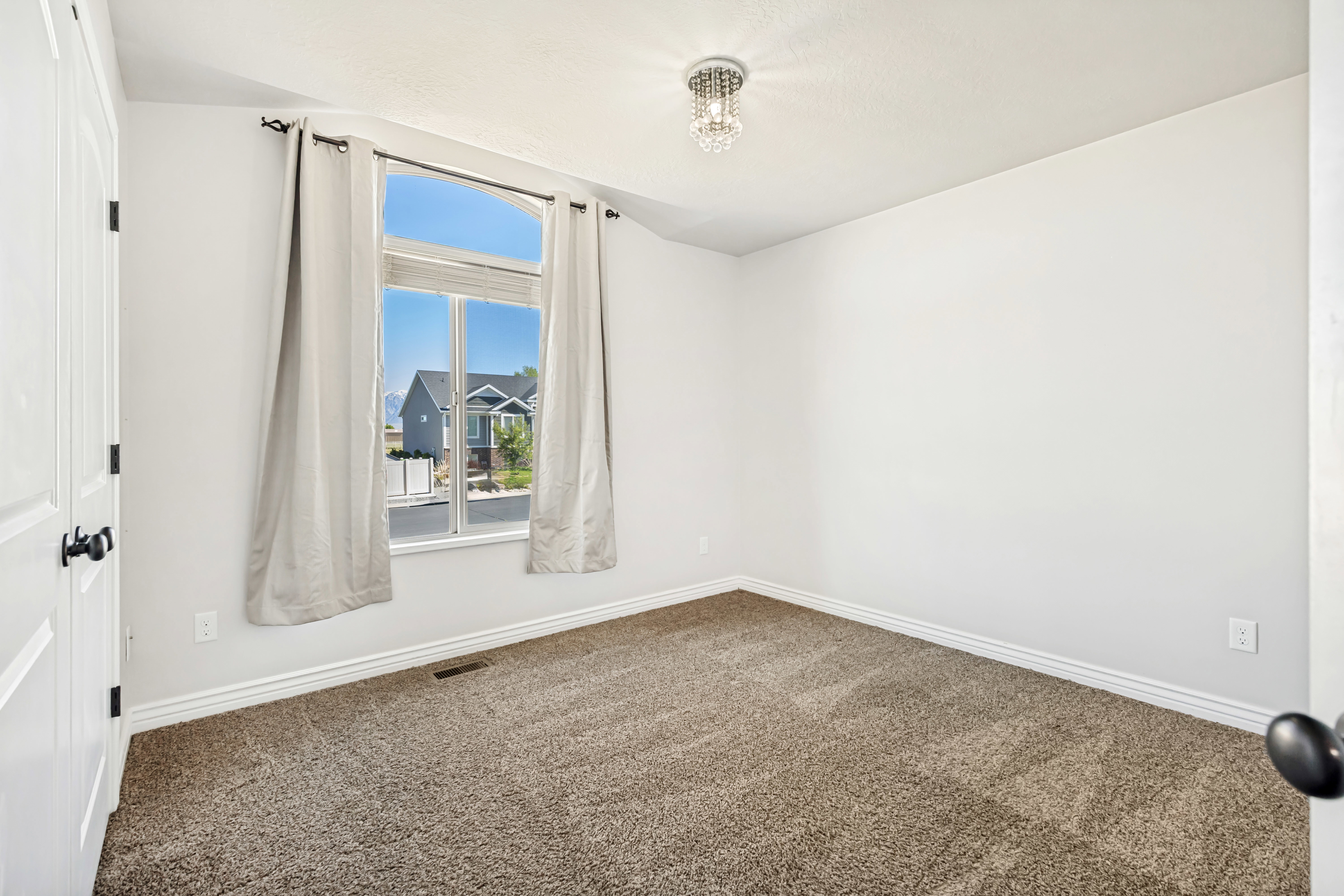 Spare room featuring dark carpet and baseboards