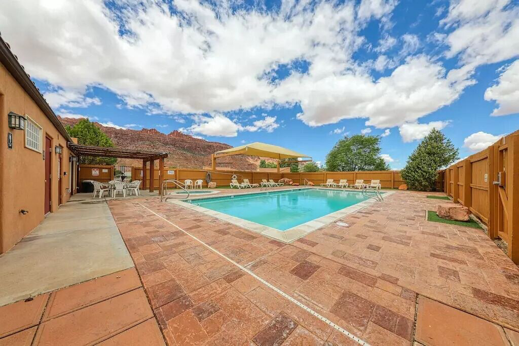 Community pool with a pergola, a patio, a fenced backyard, a mountain view, and outdoor dining area