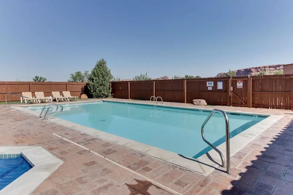 Community pool with a patio area and a gate