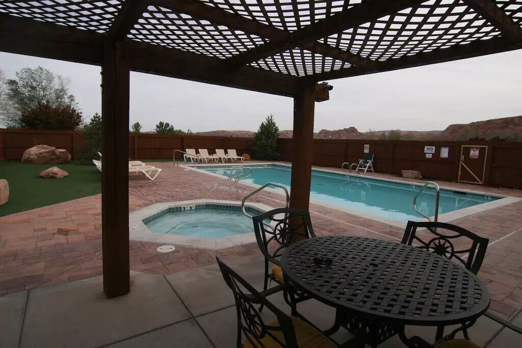 Community pool with a fenced backyard, a patio, a pergola, a community hot tub, and outdoor dining space