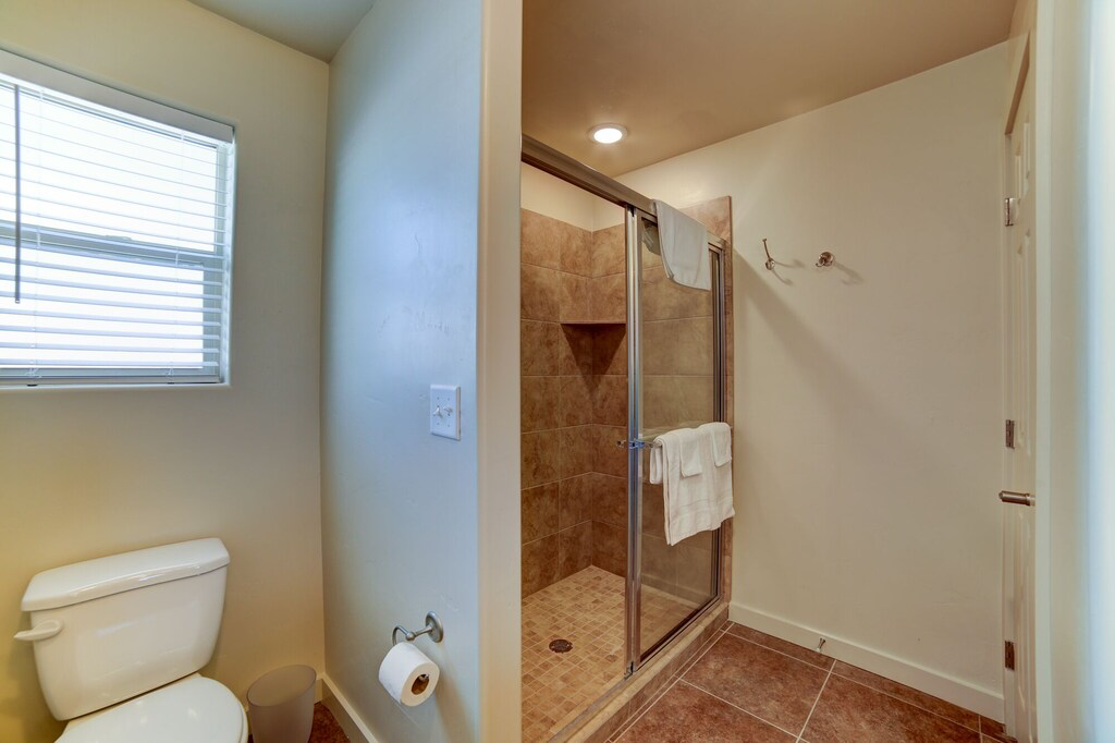 Full bath with a shower stall and tile patterned floors