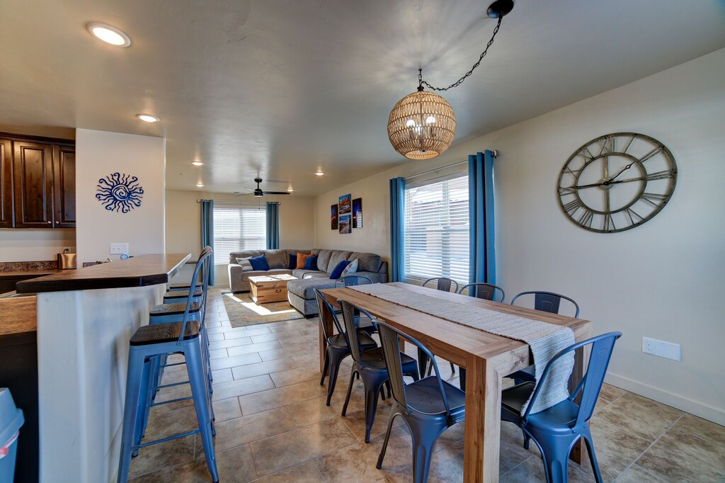 Dining area with a ceiling fan, light tile patterned floors, and suspended lighting