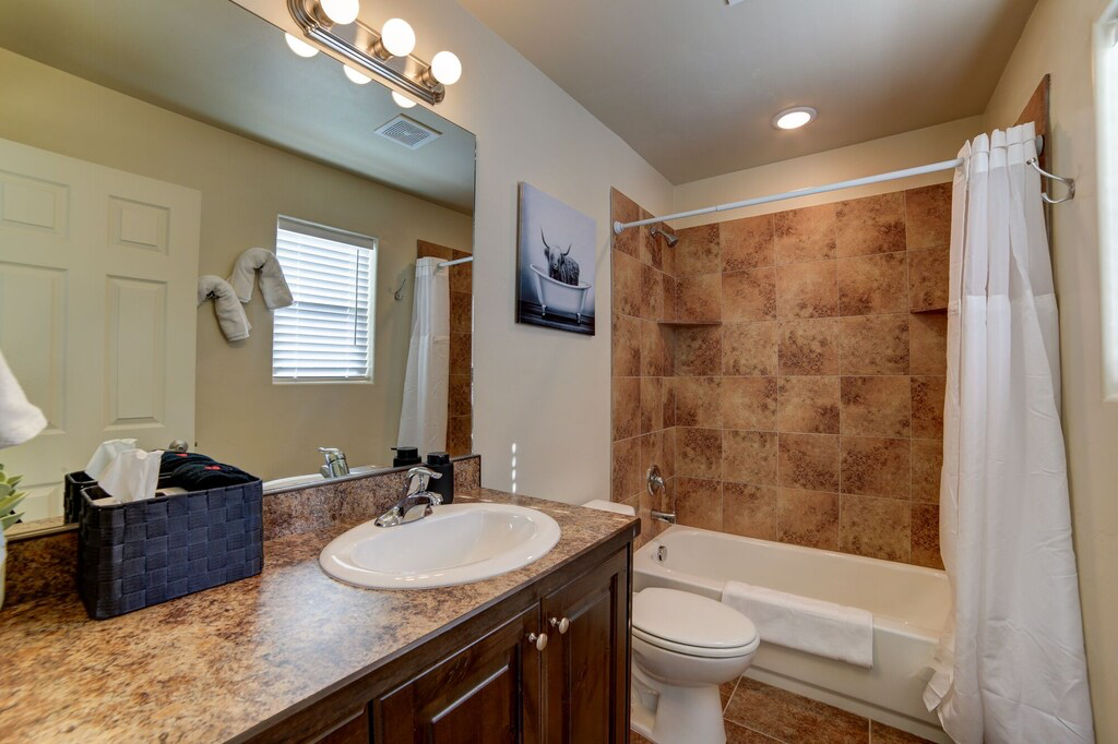 Bathroom featuring vanity, shower / bath combo, and light tile patterned floors