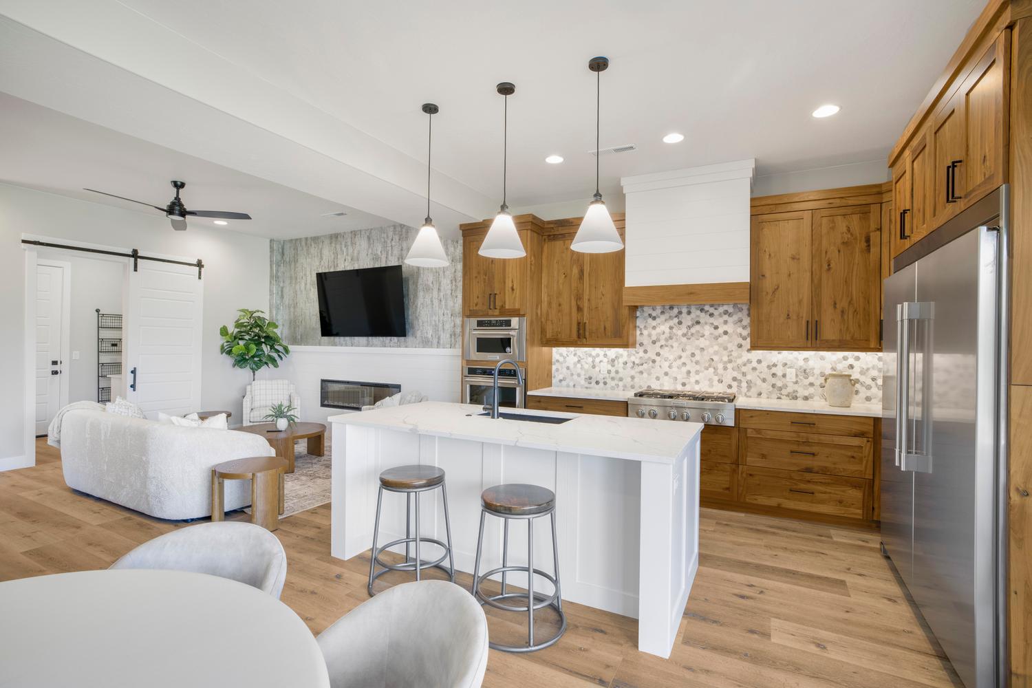 Kitchen with a barn door, open floor plan, stainless steel appliances, a breakfast bar area, and light stone countertops