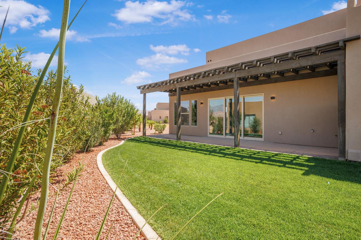 View of grassy yard with a pergola and a patio area