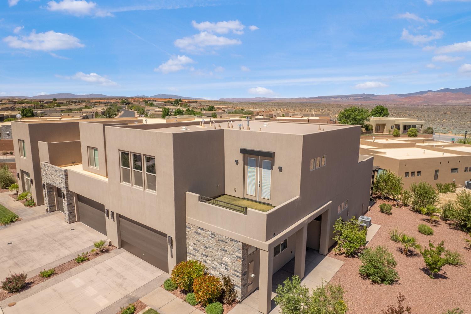 View of property featuring a mountain view, a garage, and driveway
