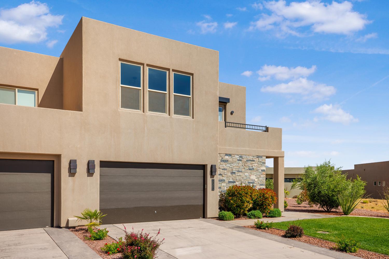 View of front of property with stucco siding, an attached garage, and driveway