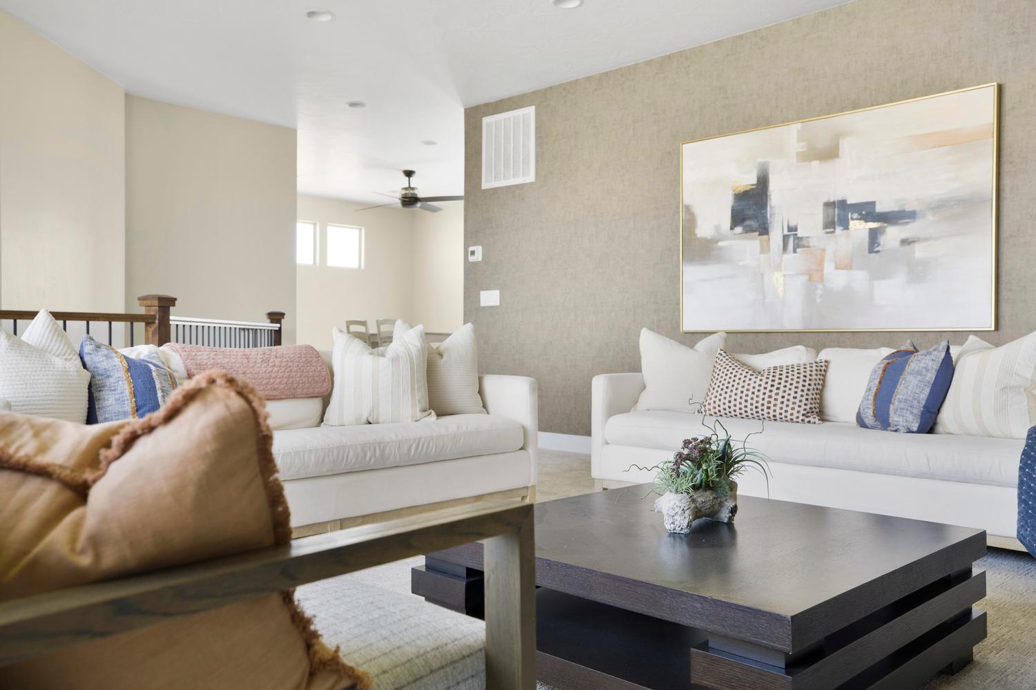 Carpeted living room with wallpapered walls and a ceiling fan