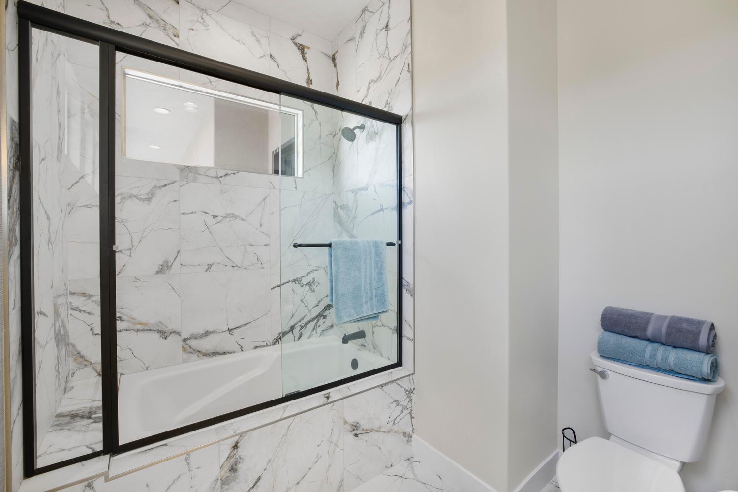 Full bathroom with toilet and enclosed tub / shower combo