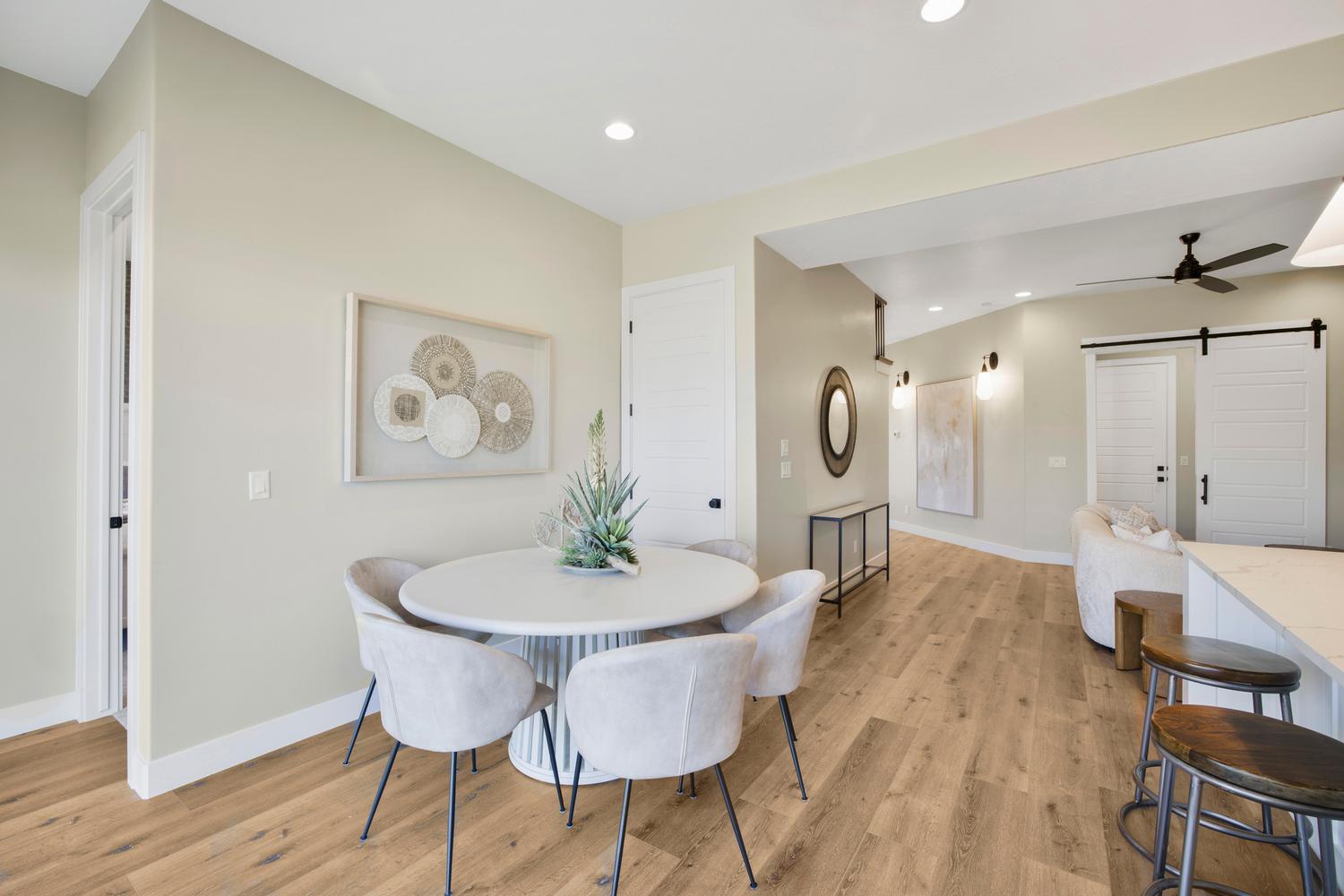 Dining room featuring a barn door, ceiling fan, light wood-type flooring, and recessed lighting