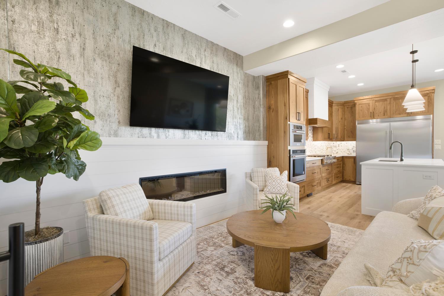 Living room with light wood finished floors, a glass covered fireplace, and recessed lighting