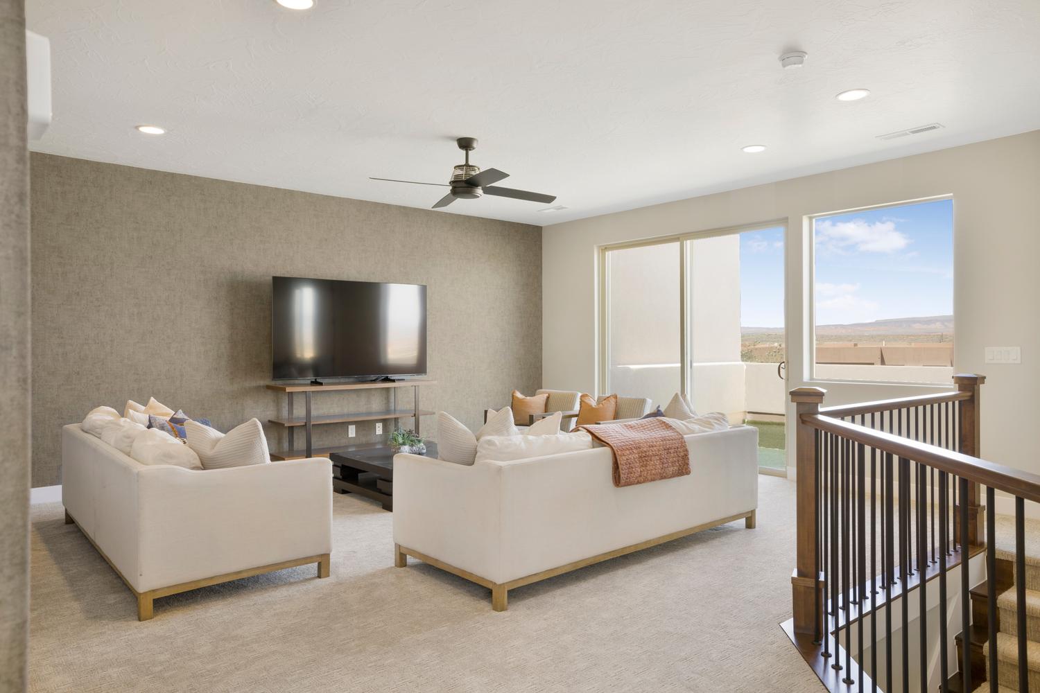 Carpeted living area with ceiling fan and recessed lighting