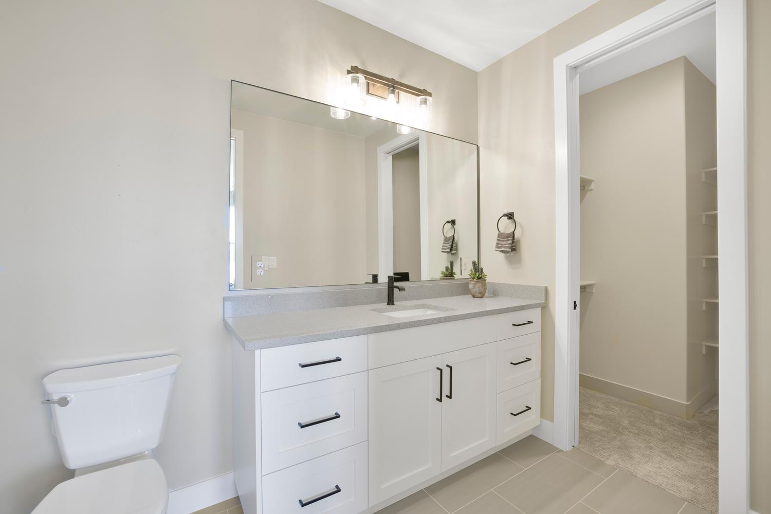 Full bathroom featuring vanity, light tile patterned floors, and a walk in closet