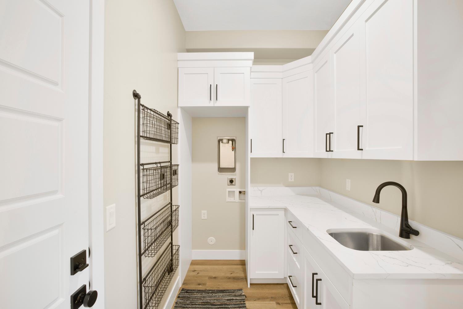 Laundry room with light wood-type flooring and cabinet space