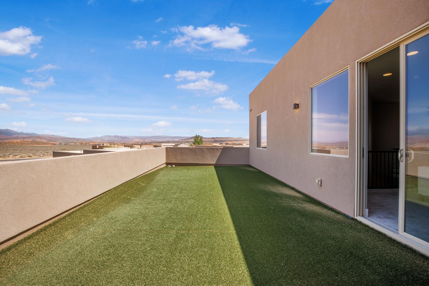View of grassy yard featuring a mountain view and a patio area
