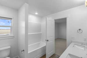 Bathroom with double vanity, a bath, and light wood finished floors