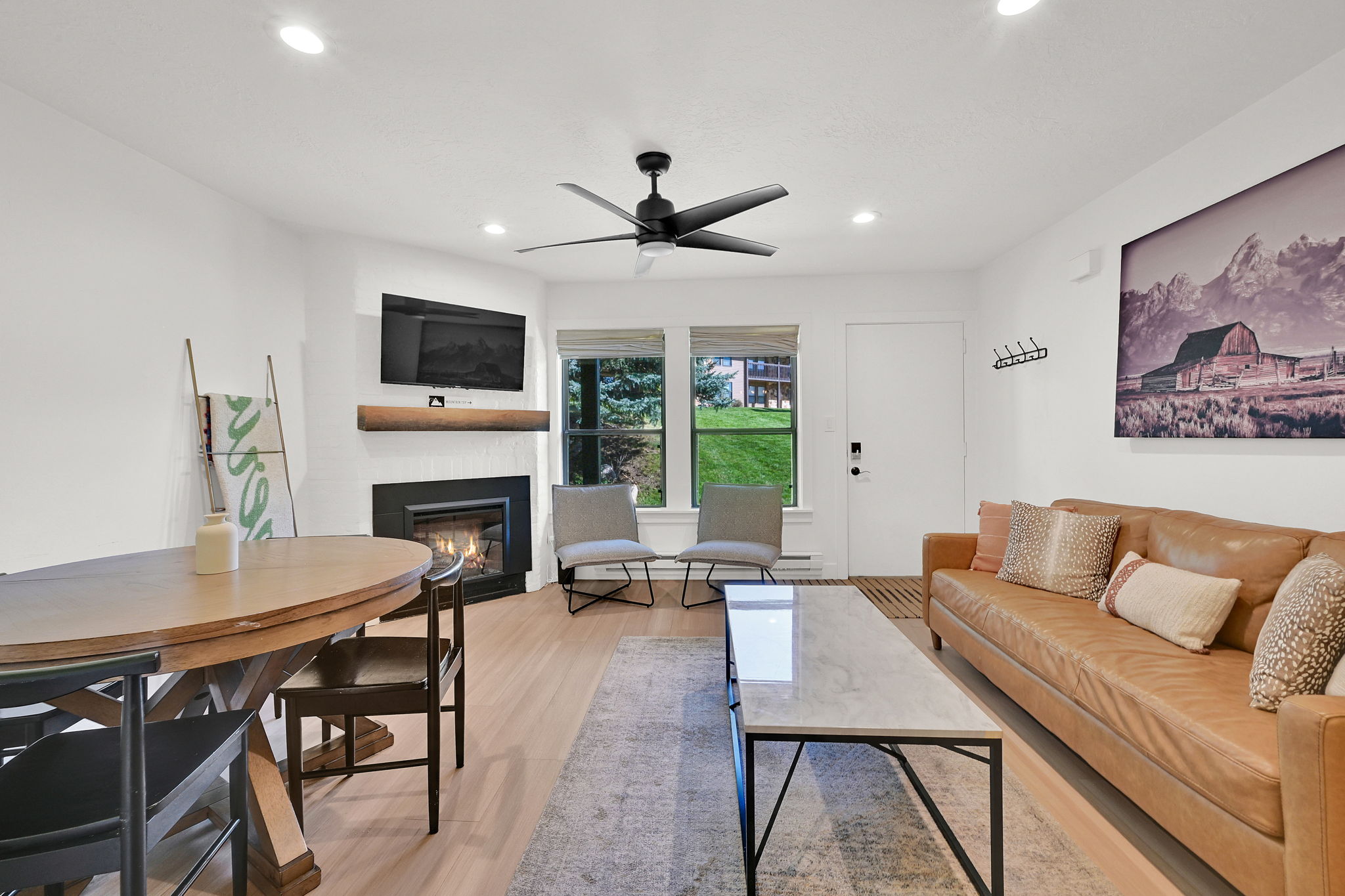 Living room with modern finishes, fireplace, dining area, LVP flooring through-out main level, roman shades.