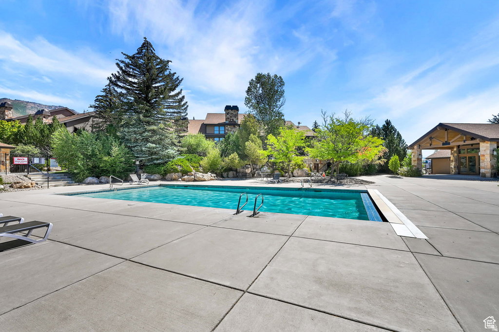 Community pool featuring a patio area and a residential view