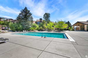 Community pool featuring a patio area and a residential view