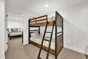 Downstairs living room with carpet, flexible occupancy space, full bathroom, nook for various functions.