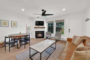 Living room with modern finishes, fireplace, dining area, LVP flooring through-out main level, roman shades.