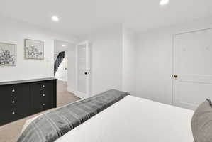Bedroom #2 with carpet and modern finishes, the door is frosted glass.