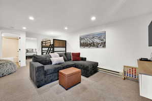 Downstairs living room with carpet, flexible occupancy space, full bathroom, nook for various functions.