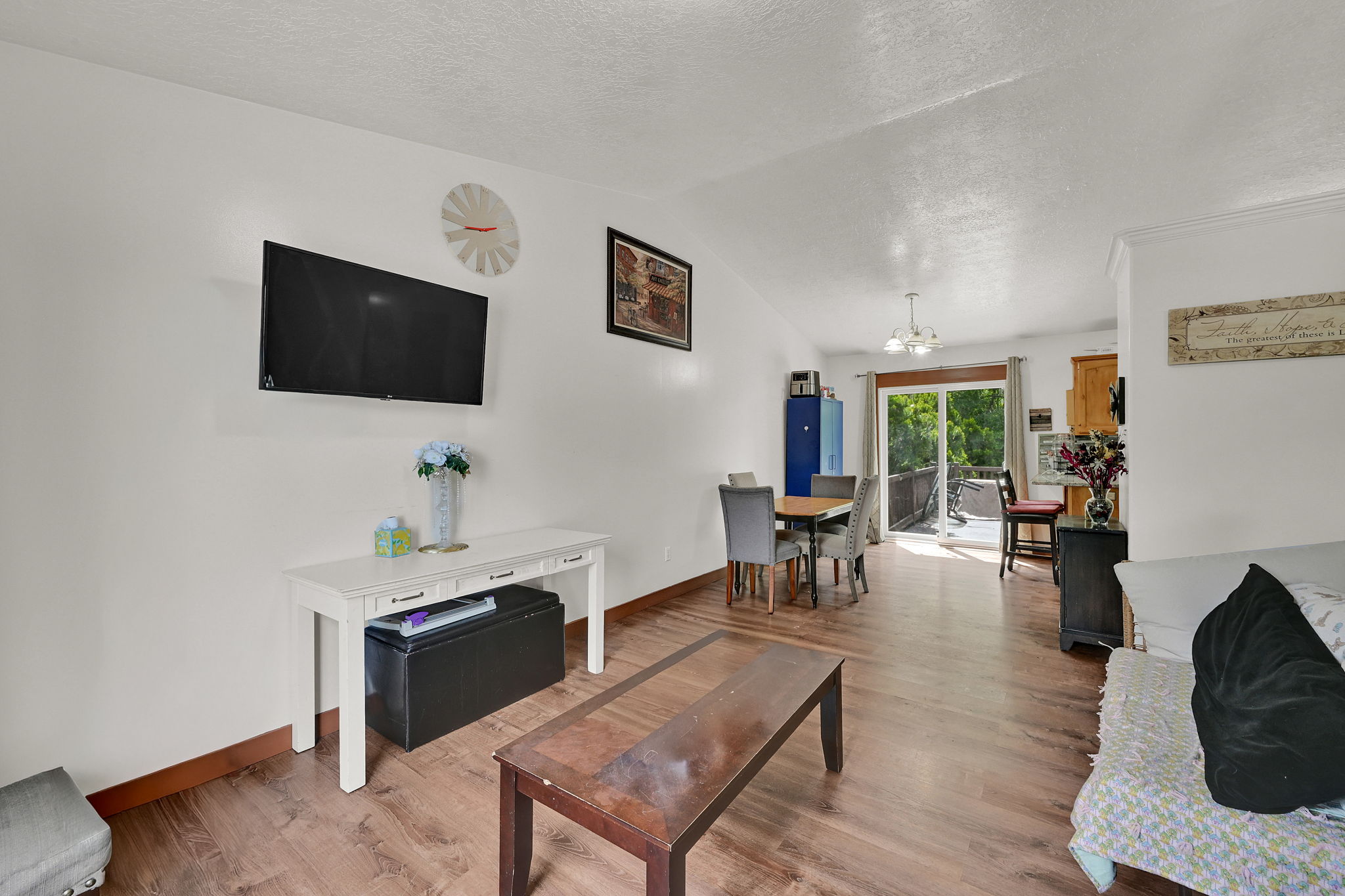 Living room with light wood-type flooring and suspended lighting
