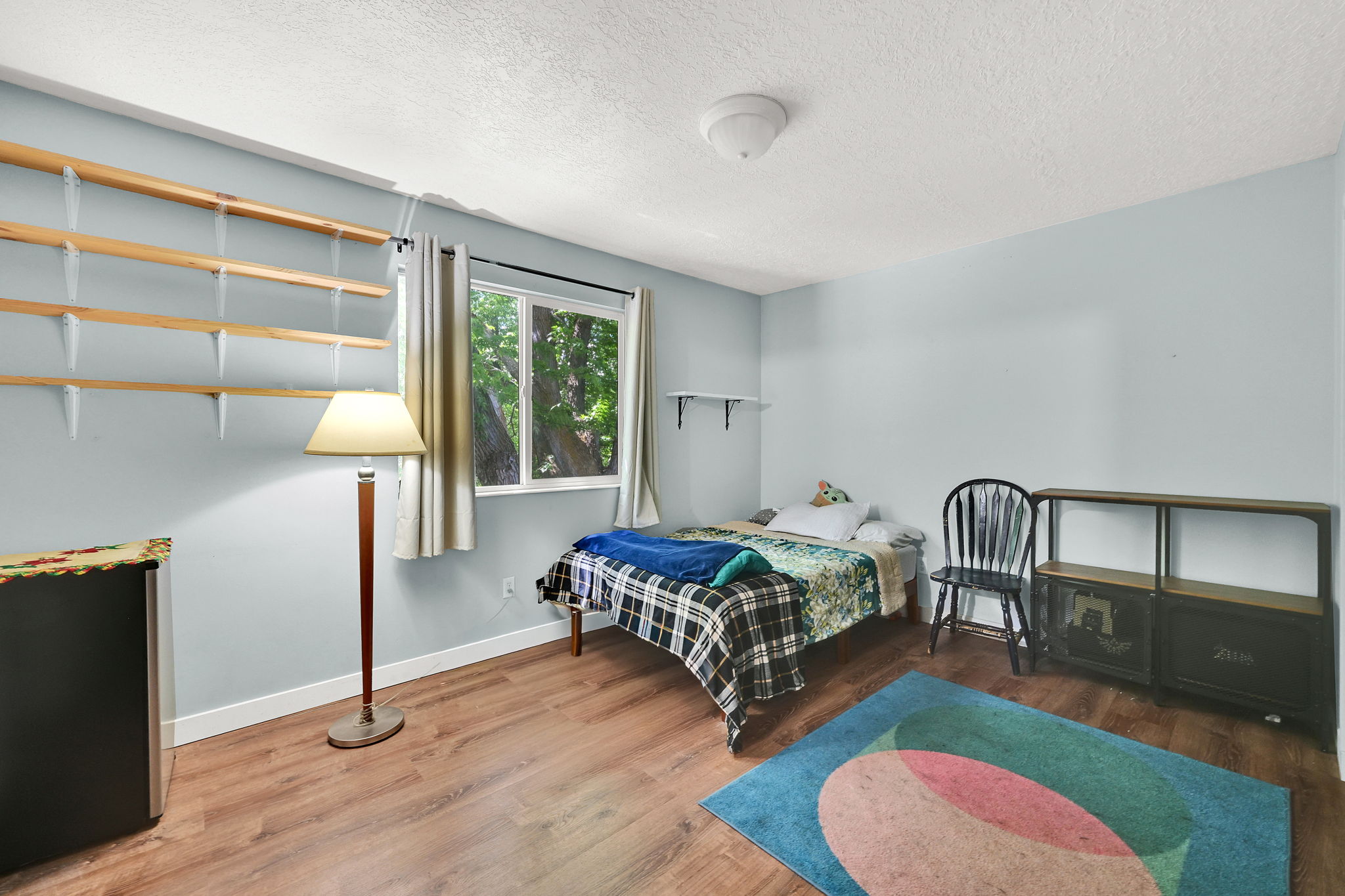 Bedroom with wood finished floors and a textured ceiling