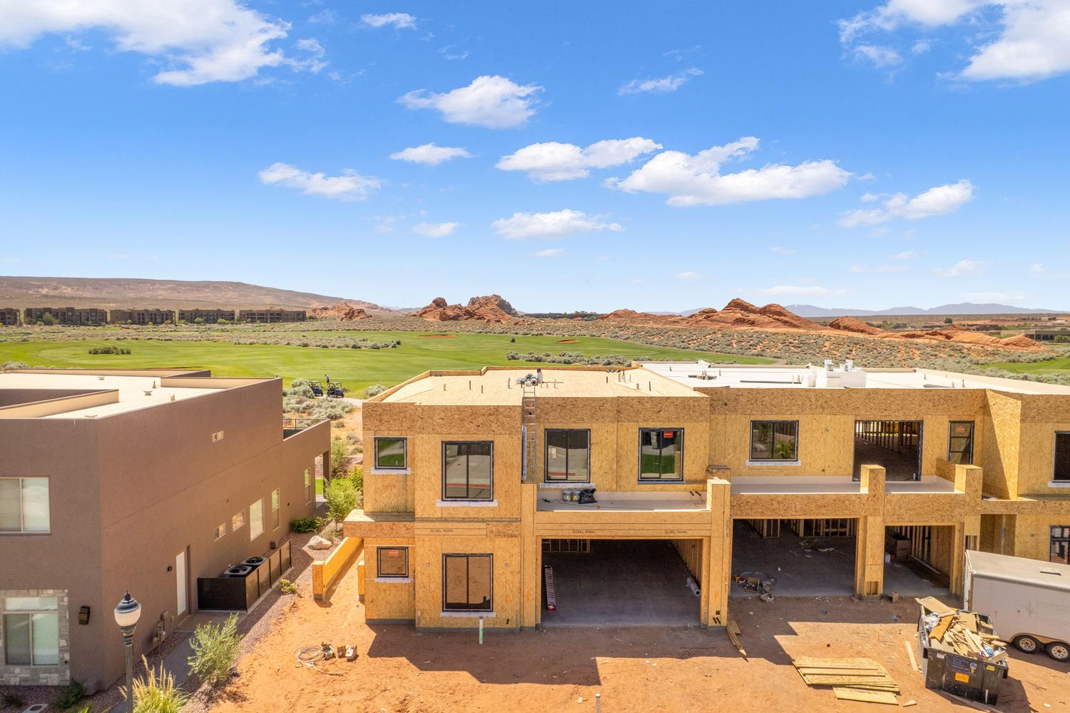 View of front of home with a mountain view, view of golf course, a patio area, and stucco siding