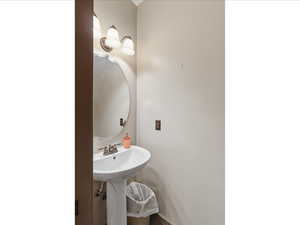 Pedestal sink with chrome-finish faucet and oval mirror