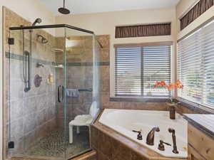 Tiled walk-in shower with a pebble floor, multiple showerheads, and bronze fixtures