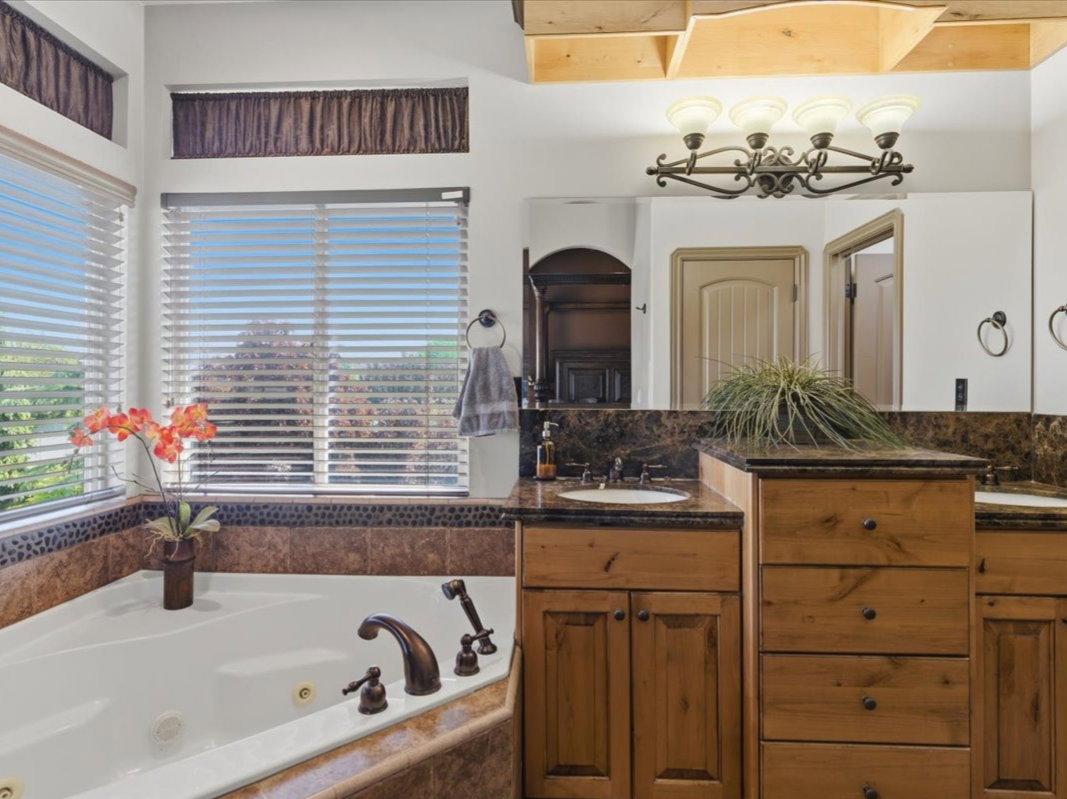Corner jetted tub featuring bronze-finish fixtures