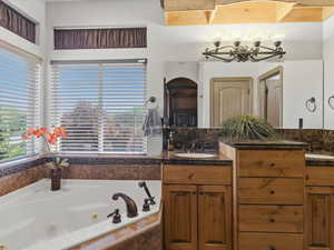 Corner jetted tub featuring bronze-finish fixtures