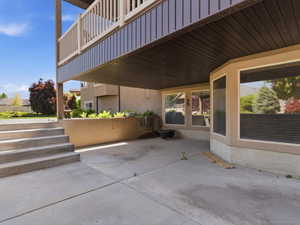 Concrete patio with multi-level steps, framed by a stucco exterior and large window array