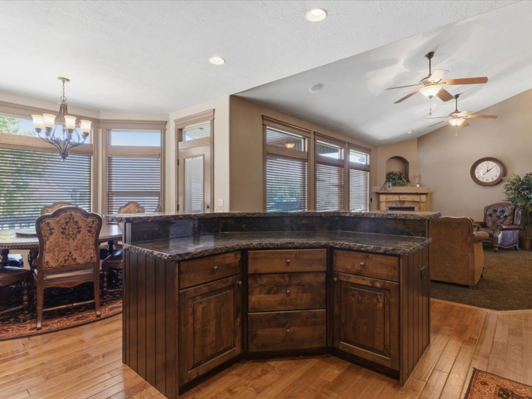 Central kitchen island with dark wood cabinetry and stone-finish countertop