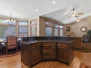 Central kitchen island with dark wood cabinetry and stone-finish countertop