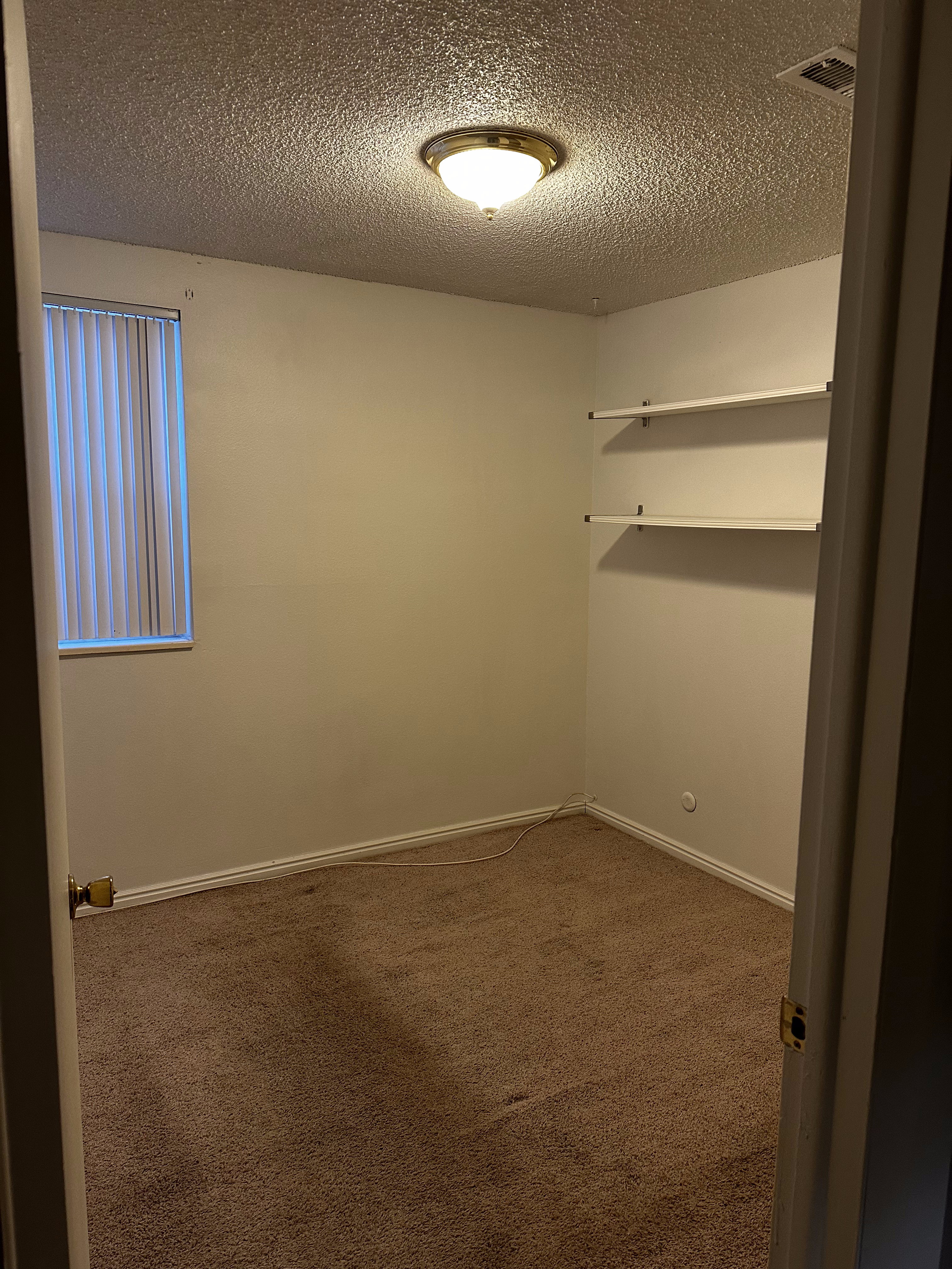 Additional view of secondary bedroom with built-in shelving for added storage.