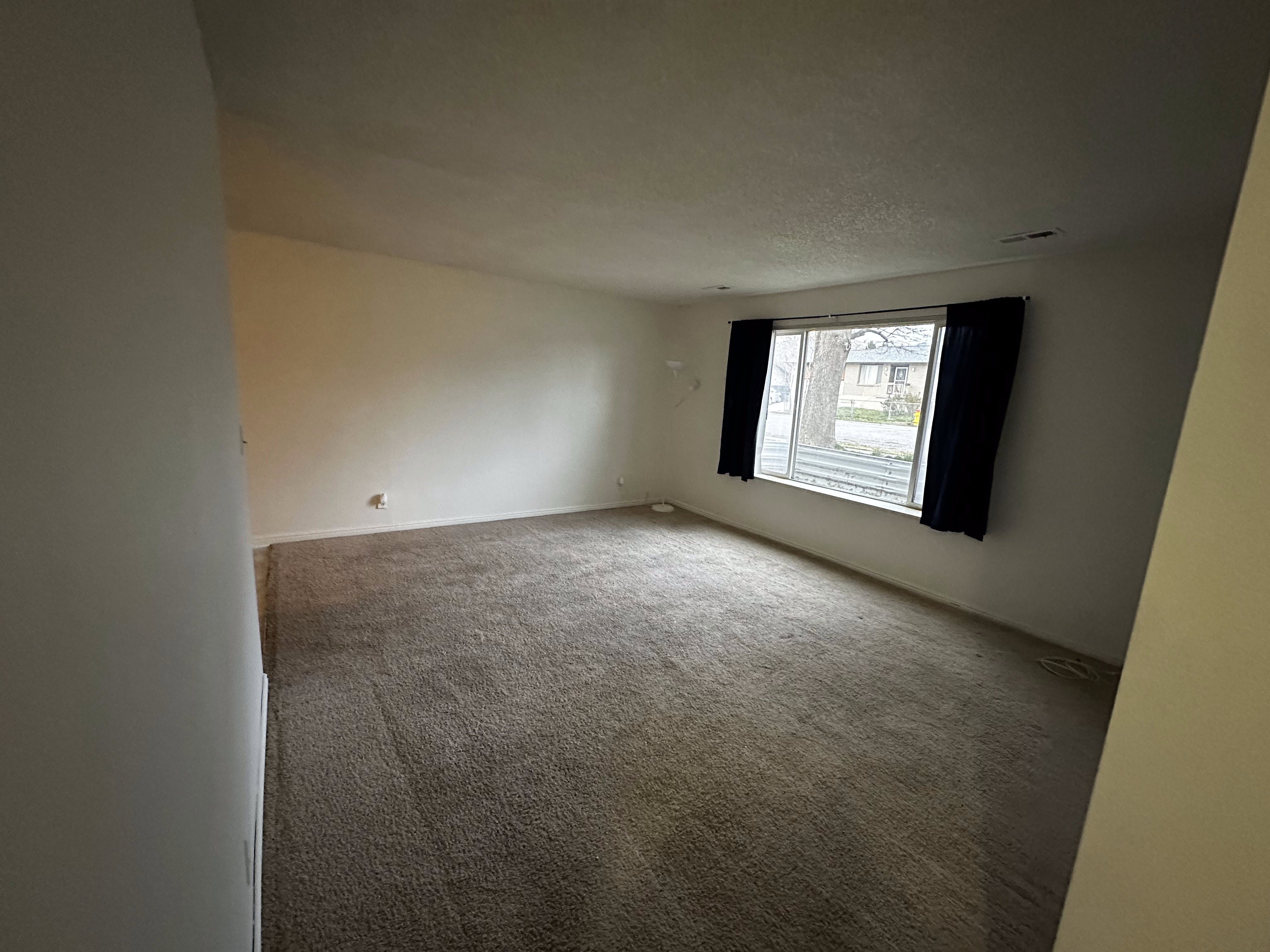 Spacious living area with natural light and an open, comfortable layout.