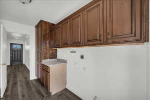 Laundry room with hookup for an electric dryer, dark wood-type flooring, cabinet space, crown molding, and hookup for a gas dryer