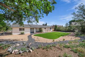Rear view of property with a fenced backyard and a putting green
