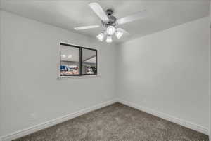 Empty room with carpet floors and a ceiling fan