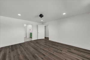 Unfurnished bedroom with recessed lighting, dark wood-style floors, and ensuite bathroom