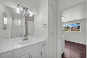 Bathroom featuring vanity, dark wood-style flooring, and washer / dryer