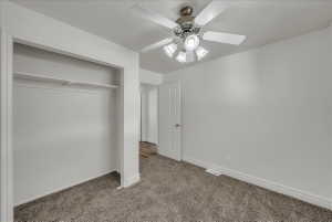 Unfurnished bedroom with light colored carpet, a ceiling fan, and a closet