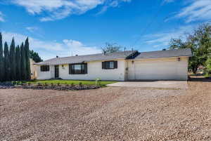 Ranch-style home with gravel driveway and an attached garage