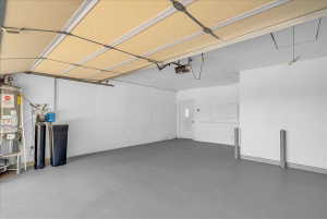 Garage featuring gas water heater and a garage door opener