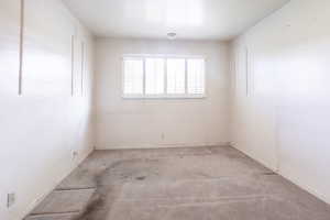 Carpeted empty room with baseboards