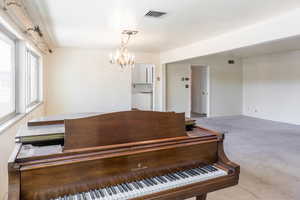 Carpeted dining area featuring hanging lights and baseboards