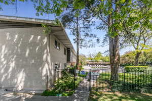 View of home's exterior featuring a fenced front yard, brick siding, and a gate